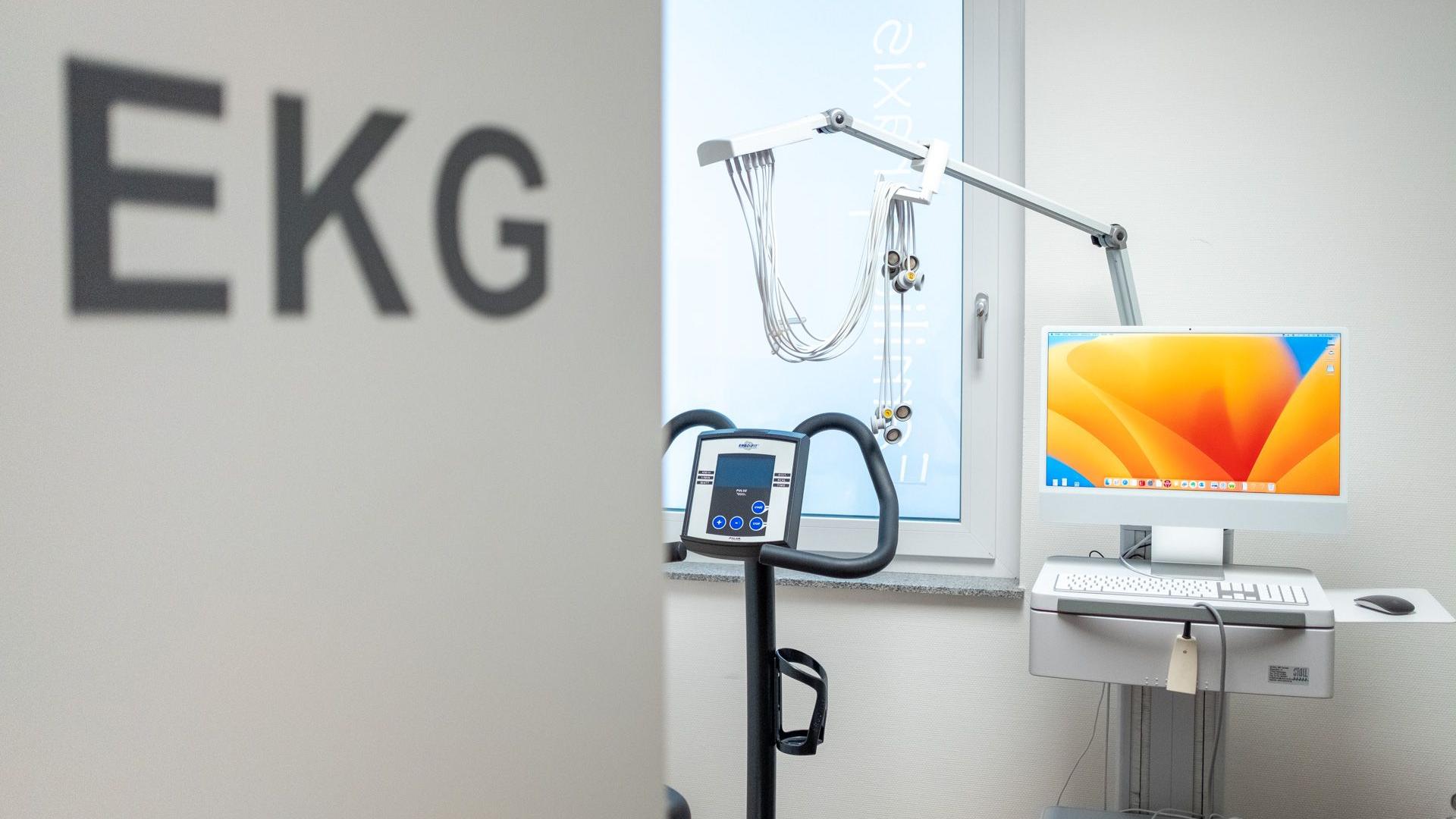 Blick ins EKG-Zimmer mit Türbeschriftung, Ergometer und EKG-Gerät. Blick ins EKG-Zimmer mit Türbeschriftung, Ergometer und EKG-Gerät.