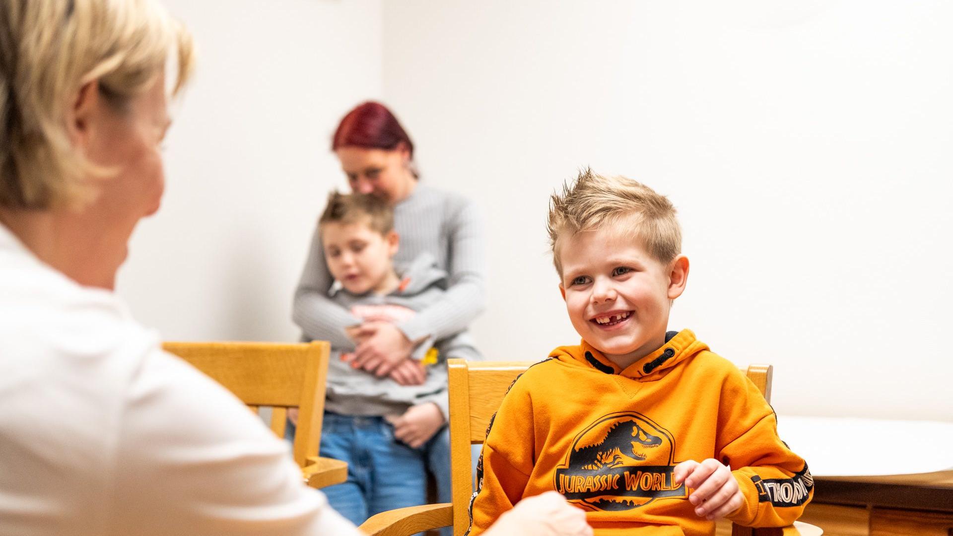 Ein Junge sitzt im Sprechzimmer bei einer Ärztin Ein Junge sitzt im Sprechzimmer bei einer Ärztin