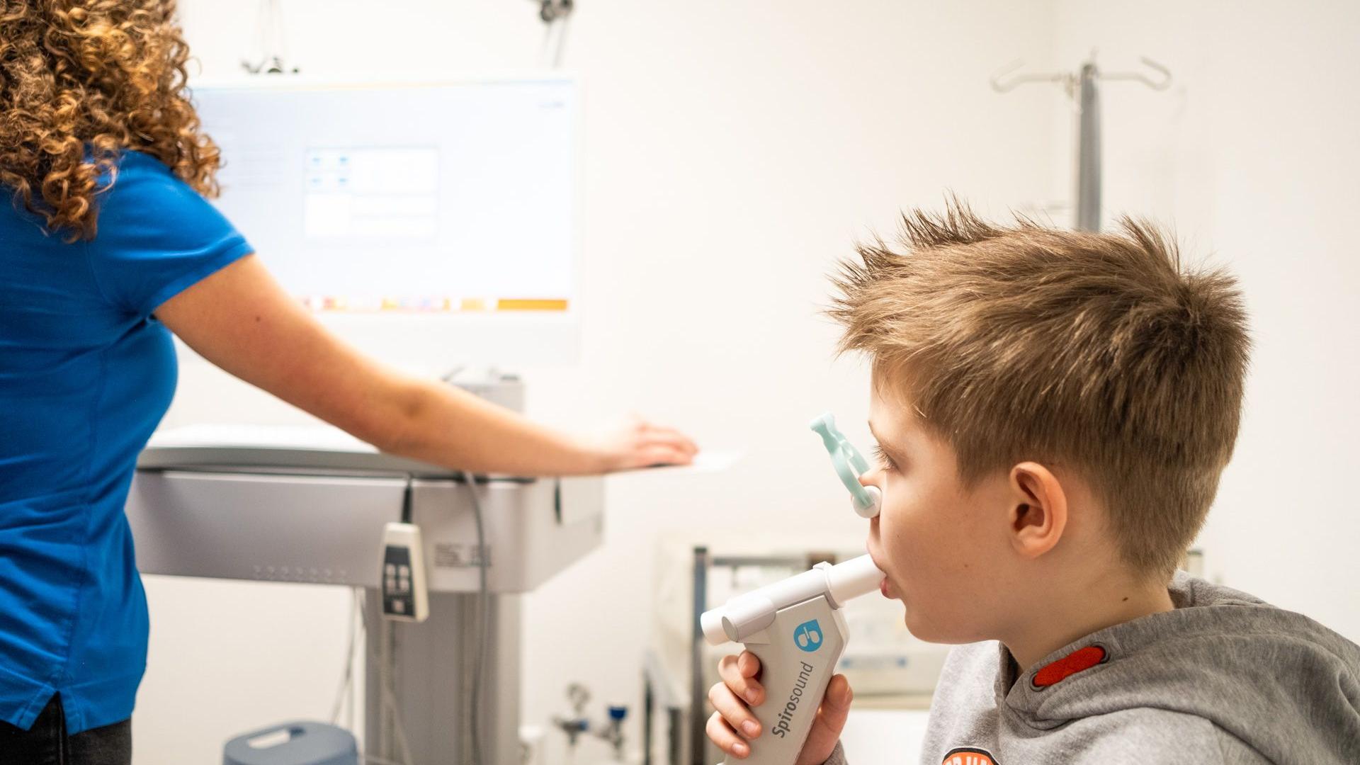 Arzthelferin führt bei einem Jungen eine Spirometrie-Untersuchung durch Arzthelferin führt bei einem Jungen eine Spirometrie-Untersuchung durch